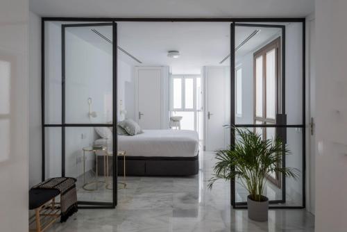 塞维利亚La casa del Lagar 10的一间卧室设有一张床和一个大型玻璃门