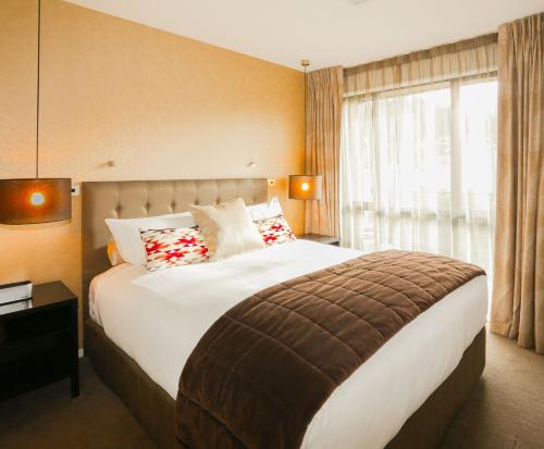 汉默温泉乡村湖泊公寓式酒店的一间卧室设有一张大床和一个窗户。