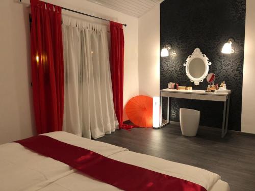 大戈里察Pilot's Manor - Airport Villa的一间卧室配有一张床、一张桌子和一面镜子