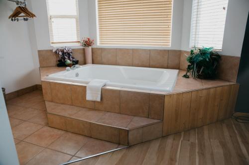 戈尔登Golden Village Lodge的带窗户的浴室设有大浴缸