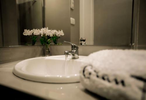 皮乌拉Hotel Gran Palma Piura的浴室水槽配有白色毛巾和镜子