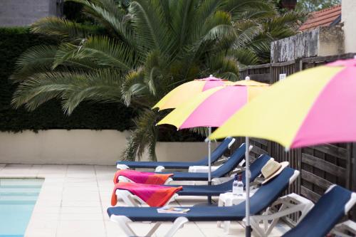 阿卡雄道方酒店的一组椅子和遮阳伞,位于游泳池旁