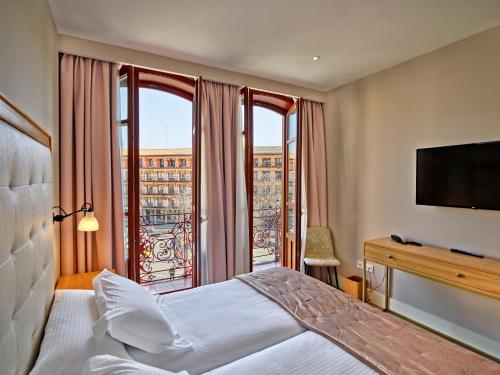 托莱多Hotel Boutique Adolfo的酒店客房设有一张床和一个大窗户
