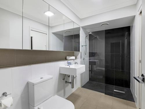 布里斯班阿特里奥公寓的浴室配有卫生间、盥洗盆和淋浴。