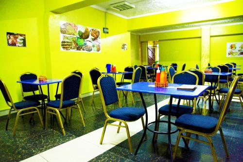 内罗毕Inks Hotel的一间设有蓝色桌椅和黄色墙壁的餐厅