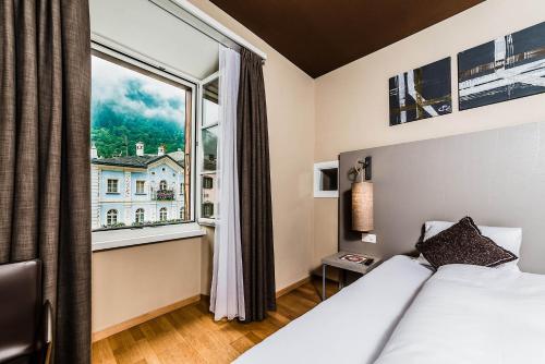 波斯基亚沃Hotel Biobistro Semadeni的酒店客房设有一张床和一个大窗户