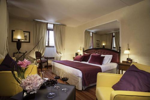 罗马Colonna Palace Hotel的酒店客房设有一张大床和一张沙发。