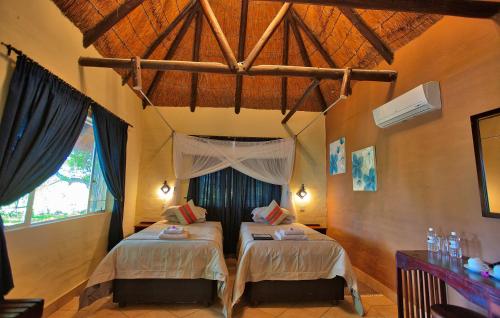 马翁Island Safari Lodge的一间卧室,配有两张床