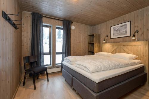 科威费耶尔Varden Fjellandsby Kvitfjell的一间卧室配有一张床和一把椅子