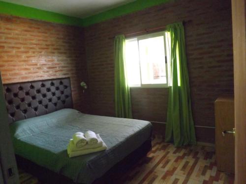 波特雷罗德加雷圣何塞度假屋的一间卧室配有一张带绿色窗帘的床和窗户。