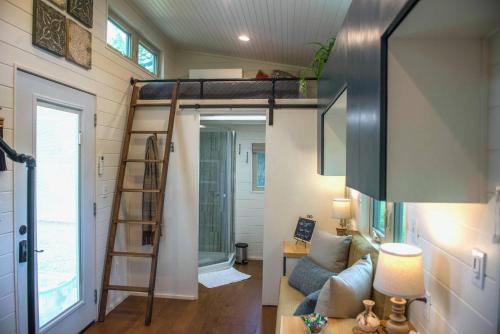 韦科Montana Escape Elegant Tiny House in Waco Near Magnolia的一间小房子,房间设有高架床