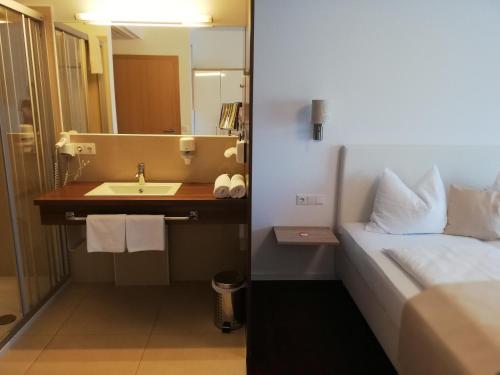 克勒希Golf Resort Klöch的一间带水槽、床和镜子的浴室