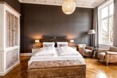 汉堡阿尔斯特布利克酒店的一间卧室配有一张大床和一把椅子