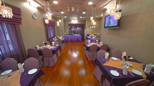 迪拜玫瑰花园公寓酒店 - 布尔迪拜的宴会厅配有桌椅和电视。