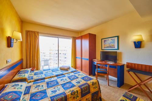 埃尔阿雷纳尔MLL帕尔马湾俱乐部度假村 的配有一张床、一张书桌和一扇窗户的酒店客房