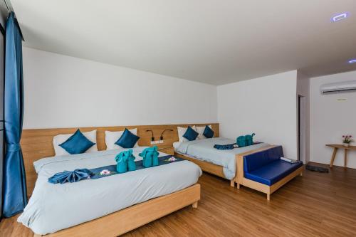 皮皮岛Paradise Resort Phi Phi-SHA Plus的一间卧室配有两张床和一张蓝色椅子