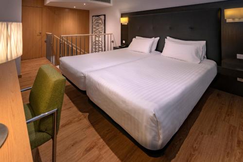 卡斯特尔德费尔斯Apartments Playa de Castelldefels的卧室配有一张白色大床和一把椅子