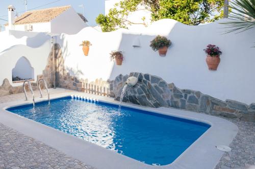扎霍拉Casa Lola的白色房子前的带瀑布的游泳池