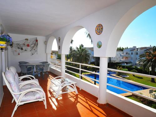 哈维亚Apartment San Esteban-1 by Interhome的一个带桌椅的阳台和一个游泳池