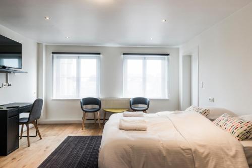 根特Parkhotel Gent Centrum的卧室配有一张床和一张桌子及椅子