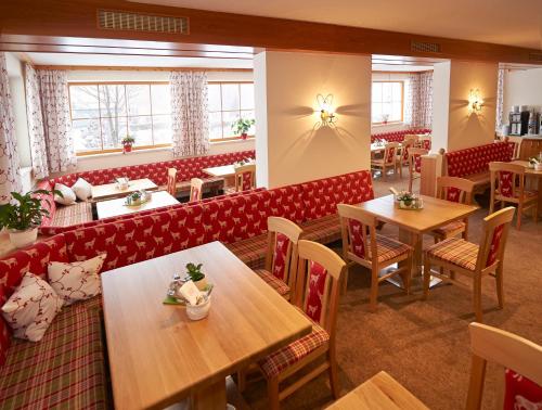 弗拉绍拉赫霍夫酒店的一间带木桌和红色摊位的餐厅