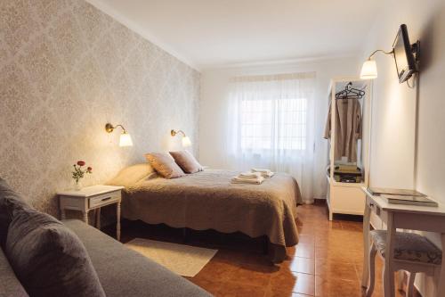 佩尼契YEY Atouguia da Baleia的一间卧室配有一张床、一张沙发和一个窗口
