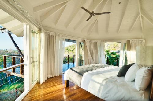阿维拉纳海滩Mikado Natural Lodge的一间白色卧室,配有床和阳台