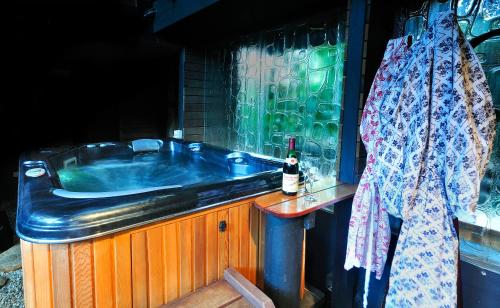 拜伦湾香巴拉@拜伦酒店的旁边配有1个带1瓶葡萄酒的浴缸。