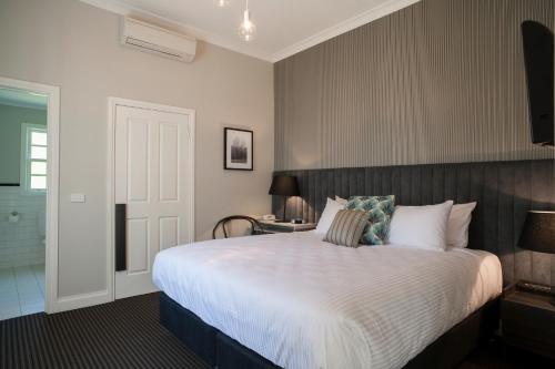 沃伯顿雅拉河奥斯卡酒店的卧室配有一张带白色棉被的大床