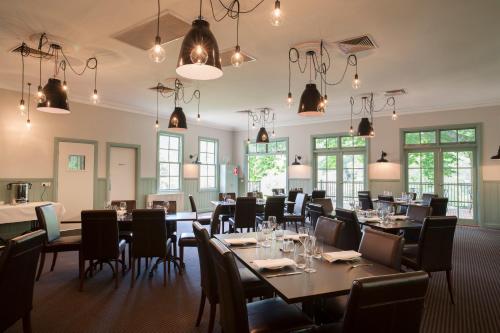 沃伯顿雅拉河奥斯卡酒店的用餐室配有桌椅和吊灯。