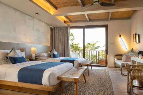 爱妮岛Maremegmeg Beach Club的酒店客房设有两张床和一个阳台。