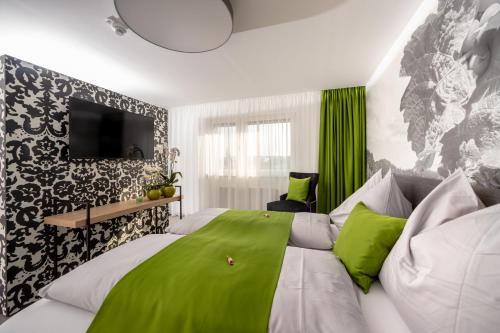 格拉茨Hotel Greenrooms的一间卧室配有一张带绿色床单的大床