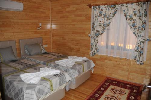 契拉勒Merhaba Hotel的配有木墙和窗户的客房内的两张床