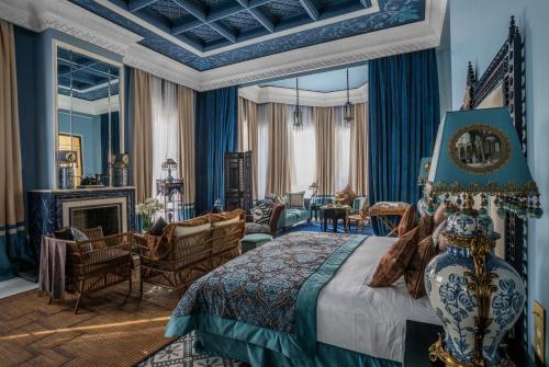 马拉喀什Palais Ronsard Relais & Chateaux的一间带特大号床的卧室和一间客厅