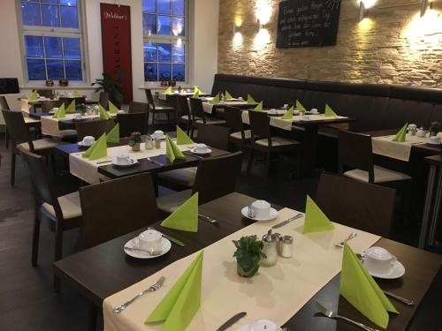 克劳斯塔尔采勒费尔德Hotel Goldene Krone的用餐室配有桌椅和绿色餐巾