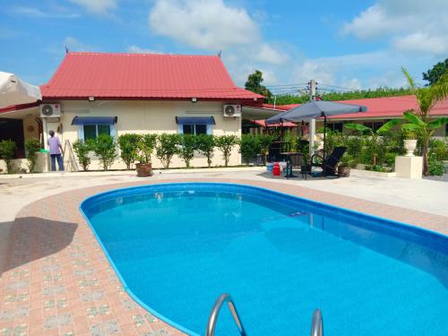 Ban Sang LuangPrivate 2 bedroom villa with Swimming pool Tropical gardens Fast Wifi smart Tv的一座红色屋顶房屋前的游泳池