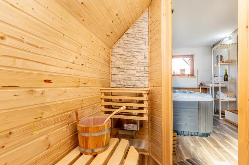 洛克维Kuća za odmor Villa.ris的一间带木墙和浴缸的桑拿浴室