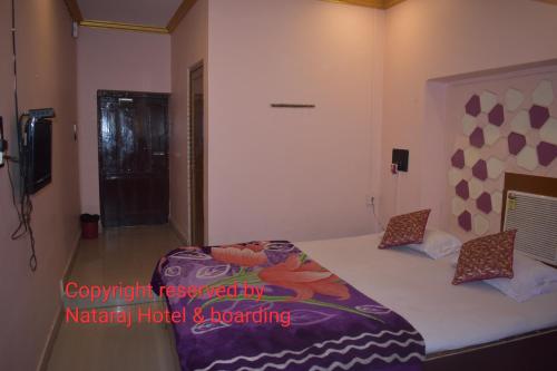 BarddhamānNataraj Hotel and Boarding的一间卧室配有一张大床和紫色毯子