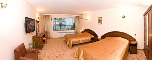 卡赞勒克Хотел ЗЛАТНА КОТВА的酒店客房设有两张床和窗户。