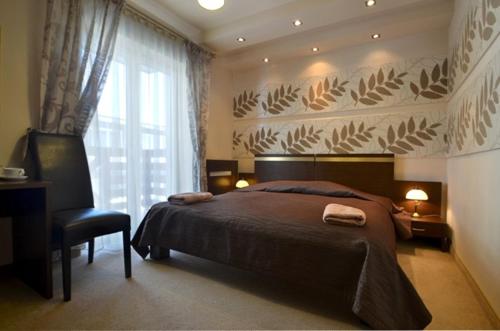克雷尼察Hotel Orlik的卧室配有床、椅子和窗户。