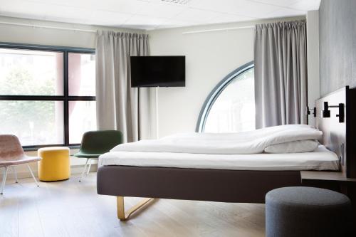 卑尔根Comfort Hotel Bergen的一间卧室设有一张大床,配有电视