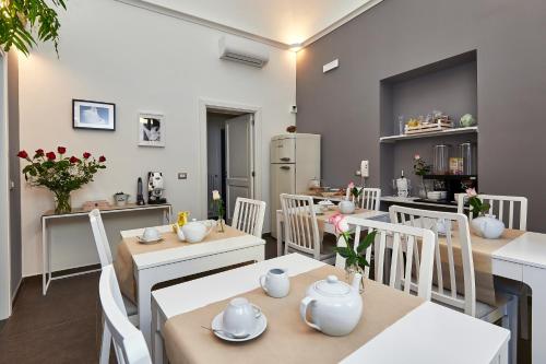 莱切Donna Teresa Guest House的一间设有白色桌子和白色椅子的餐厅