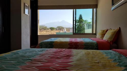 科利马Suites Lagunas的一间卧室设有两张床和一个美景窗户。