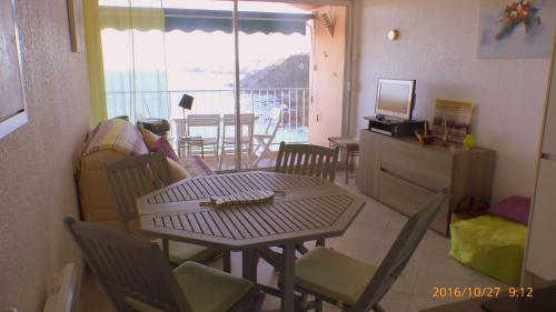 滨海巴纽尔斯Face à la mer Résidence Les Elmes的一间带桌椅的客厅和一个阳台