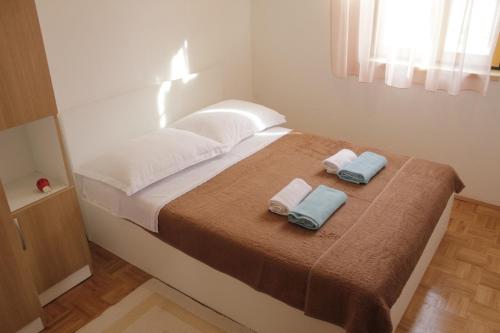 帕什曼Holiday home Pavica K的一间卧室配有一张床,上面有两条毛巾