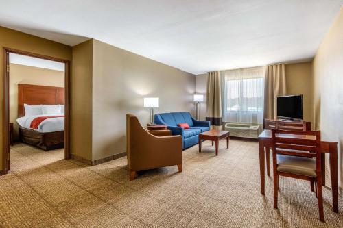 麦库姆Comfort Inn & Suites的酒店客房,配有床和蓝色的沙发