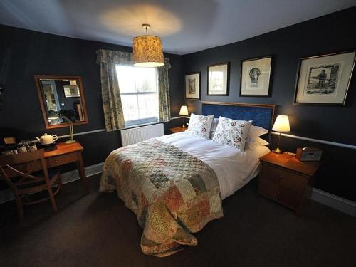 伊斯特布恩蓝布酒店的一间卧室配有一张床、一张书桌和一个窗户。