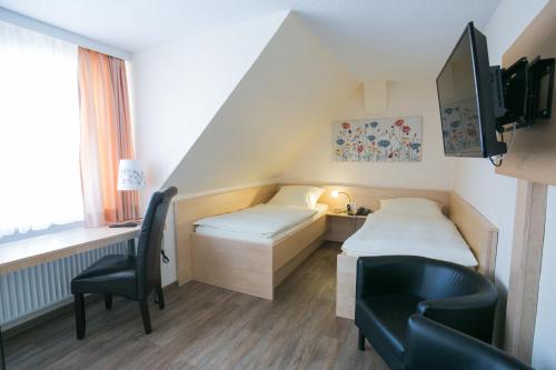 希尔德斯海姆伯格梅特卡佩旅馆的客房设有两张床、一张桌子和一把椅子。