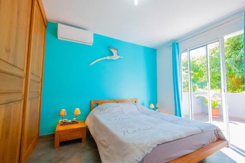 勒唐蓬"Entre Mer et Montagne"的蓝色的卧室,墙上有一张床和一只鸟
