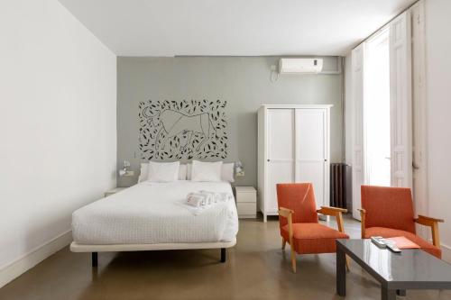 马德里马图特11号公寓的一间卧室配有一张床、两把椅子和一张桌子